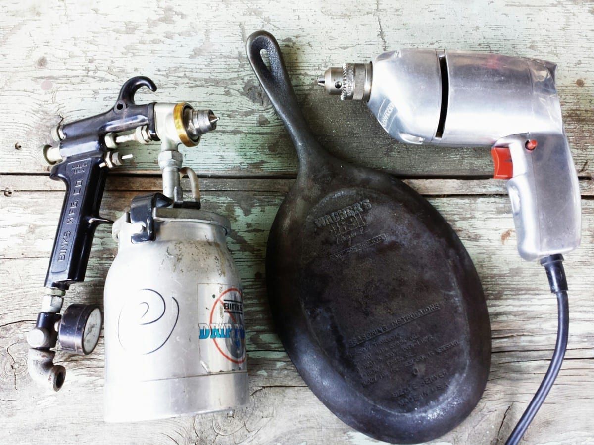 Paint gun, old cast iron skillet, and an old silver metal drill